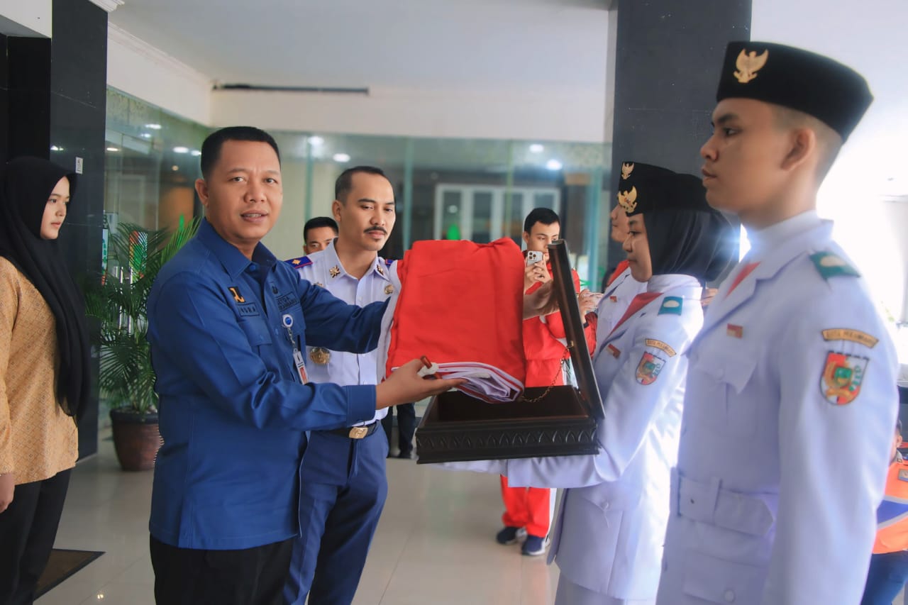 Sekdako Pekanbaru Indra Pomi Nasution menerima duplikat bendera pusaka Merah Putih dari pasukan pengibar bendera pusaka (paskibra).